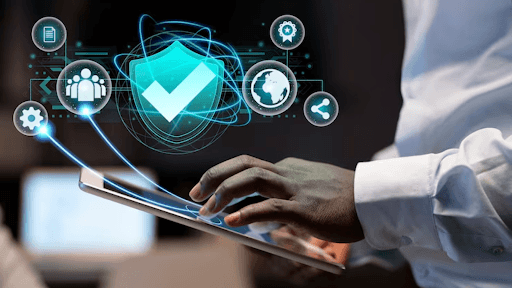 Person using tablet with holographic cybersecurity shield